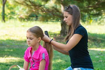 Image showing Girl combing hair girl