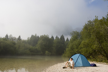 Image showing Man sitting beside his tent