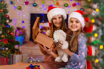 Image showing Mom and daughter opened the Christmas box with a gift and looked into the frame