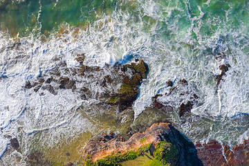 Image showing Water flowing over coastal rocks and eroded rock chasms