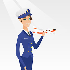 Image showing Cheerful airline pilot with the model of airplane.