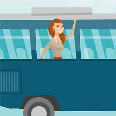 Image showing Young caucasian woman waving hand from bus window.