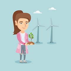 Image showing Caucasian worker of wind farm holding small plant.