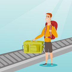 Image showing Man picking up suitcase from conveyor belt.