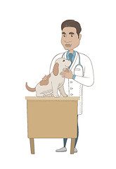 Image showing Young hispanic veterinarian examining dog.