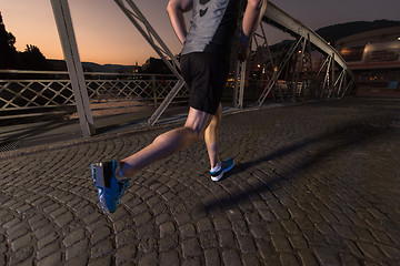 Image showing man jogging across the bridge in the city