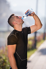 Image showing man drinking water from a bottle after jogging