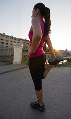 Image showing athlete woman warming up and stretching