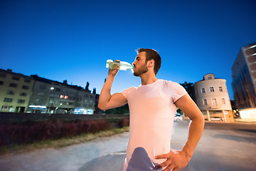 Image showing man drinking water after running session