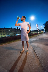 Image showing man drinking water after running session