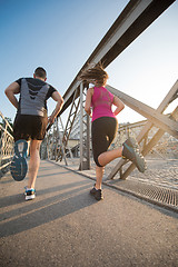 Image showing young couple jogging across the bridge in the city