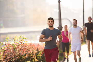 Image showing group of young people jogging in the city