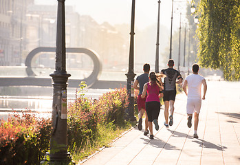 Image showing group of young people jogging in the city