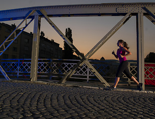 Image showing woman jogging across the bridge in the city