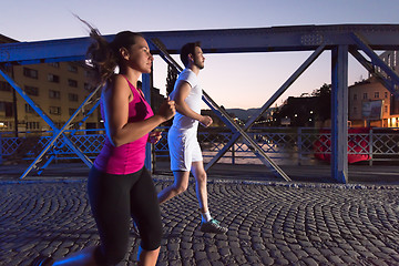 Image showing couple jogging across the bridge in the city