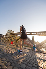 Image showing man jogging across the bridge at sunny morning