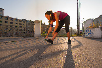 Image showing athlete woman warming up and stretching