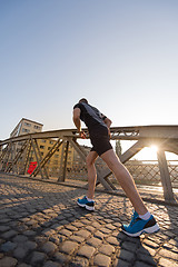 Image showing man jogging across the bridge at sunny morning