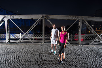 Image showing couple jogging across the bridge in the city