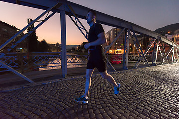 Image showing man jogging across the bridge in the city