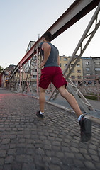 Image showing man jogging across the bridge at sunny morning