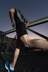 Image showing man jogging across the bridge in the city