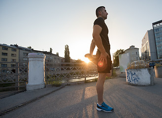 Image showing athlete man warming up and stretching