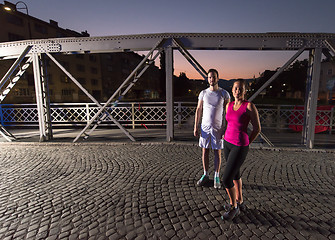 Image showing couple jogging across the bridge in the city