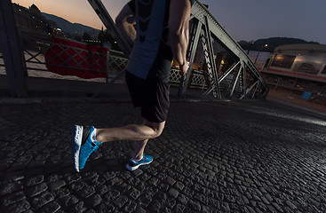 Image showing man jogging across the bridge in the city