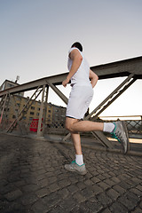 Image showing man jogging across the bridge at sunny morning