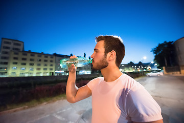 Image showing man drinking water after running session