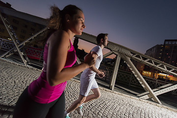 Image showing couple jogging across the bridge in the city