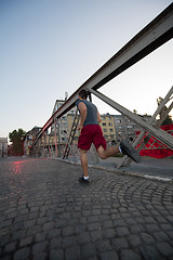 Image showing man jogging across the bridge at sunny morning