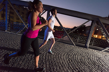 Image showing couple jogging across the bridge in the city