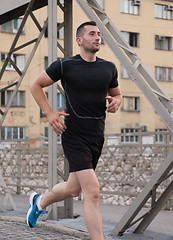 Image showing man jogging across the bridge at sunny morning