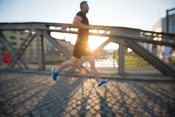 Image showing man jogging across the bridge at sunny morning