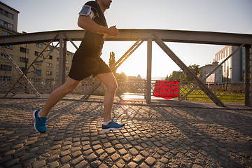 Image showing man jogging across the bridge at sunny morning