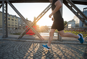 Image showing man jogging across the bridge at sunny morning