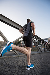 Image showing man jogging across the bridge at sunny morning