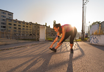 Image showing athlete woman warming up and stretching