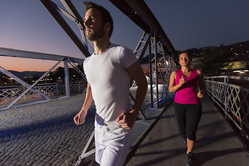 Image showing couple jogging across the bridge in the city