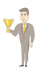 Image showing Young caucasian businessman holding a trophy.