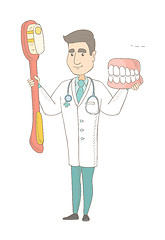 Image showing Dentist with dental jaw model and toothbrush.