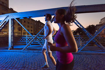 Image showing couple jogging across the bridge in the city