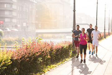 Image showing group of young people jogging in the city