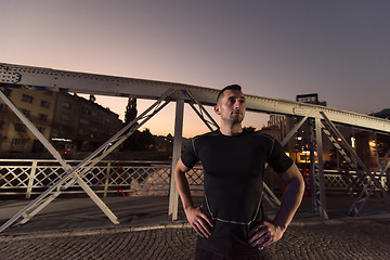 Image showing man jogging across the bridge in the city