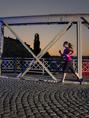 Image showing woman jogging across the bridge in the city