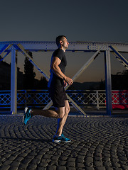 Image showing man jogging across the bridge in the city