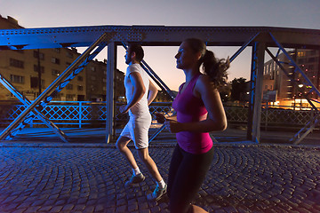 Image showing couple jogging across the bridge in the city