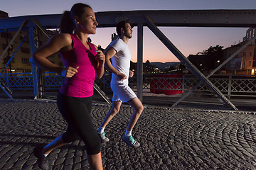 Image showing couple jogging across the bridge in the city